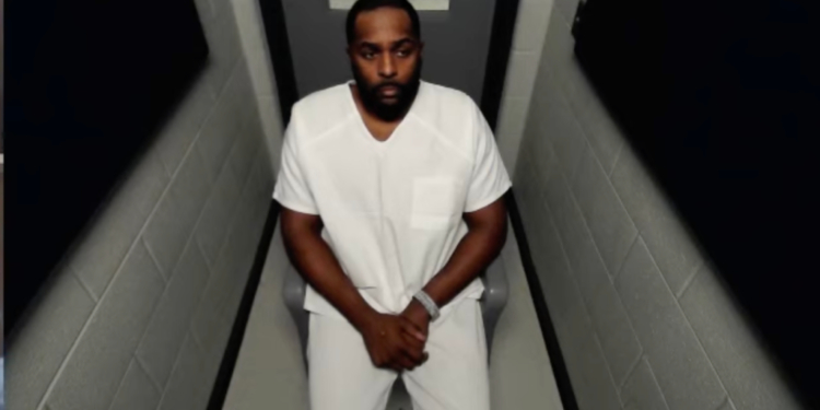 Former University of Michigan coach Sherrone Moore in a white jumpsuit during a court hearing.