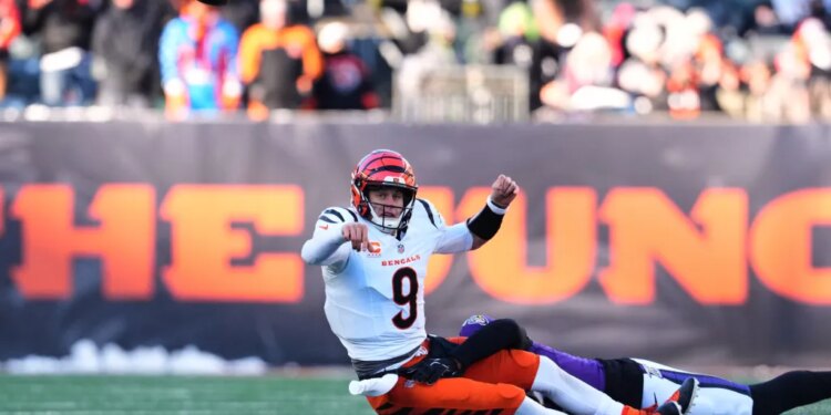 Cincinnati Bengals quarterback Joe Burrow (9) throws as he is tackled by Baltimore Ravens linebacker Kyle van Noy during the second half of an NFL football game, Sunday, Dec. 14, 2025, in Cincinnati.