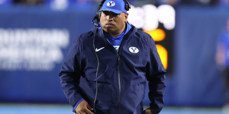 BYU coach Kalani Sitake wearing a headset and blue cap with a 'Y' logo.