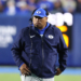 BYU coach Kalani Sitake wearing a headset and blue cap with a 'Y' logo.