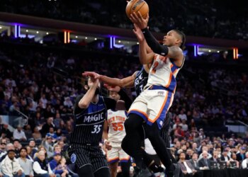 New York Knicks guard Miles McBride (R) puts up a shot past Orlando Magic center Goga Bitadze (L) in the second half at Madison Square Garden in New York, Sunday, December 07, 2025.