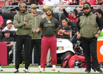 Kyler Murray, injured Arizona Cardinals quarterback, watches from the sideline during an NFL football game.