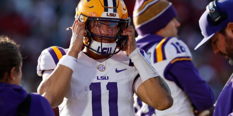 LSU quarterback Michael van Buren Jr. (11) puts on his helmet before a play against Oklahoma during the first half of an NCAA college football game Saturday, Nov. 29, 2025, in Norman, Okla.