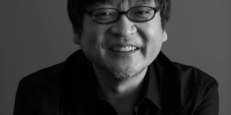 A black-and-white photo of film director Mamoru Hosoda.