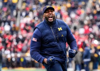 Michigan coach Sherrone Moore cheers on the field.