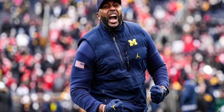 Michigan coach Sherrone Moore cheers on the field.