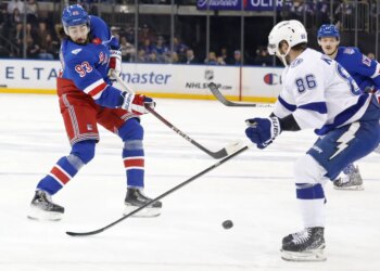 New York Rangers center Mika Zibanejad (93) takes a shot as Tampa Bay Lightning right wing Nikita Kucherov (86) defends.