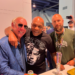 Ric Flair, Mike Tyson, and a man with a beard posing together.