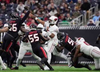 Arizona Cardinals quarterback Jacoby Brissett passes as Houston Texans defensive ends Denico Autry, Danielle Hunter (55), and Will Anderson Jr. (51) pressure him.