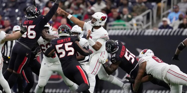 Arizona Cardinals quarterback Jacoby Brissett passes as Houston Texans defensive ends Denico Autry, Danielle Hunter (55), and Will Anderson Jr. (51) pressure him.