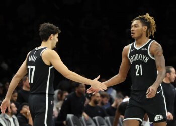 Brooklyn Nets players Ben Saraf #77 and Noah Clowney #21 shake hands.