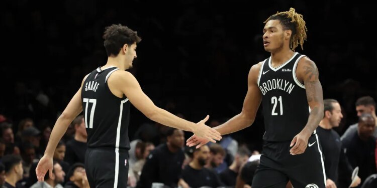 Brooklyn Nets players Ben Saraf #77 and Noah Clowney #21 shake hands.