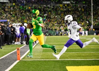 Oregon Ducks quarterback Dante Moore (5) rushing for a touchdown as James Madison Dukes safety Tyler Brown (13) defends.