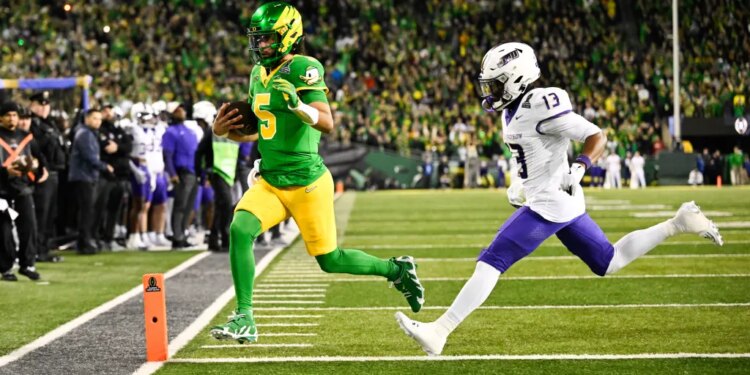 Oregon Ducks quarterback Dante Moore (5) rushing for a touchdown as James Madison Dukes safety Tyler Brown (13) defends.