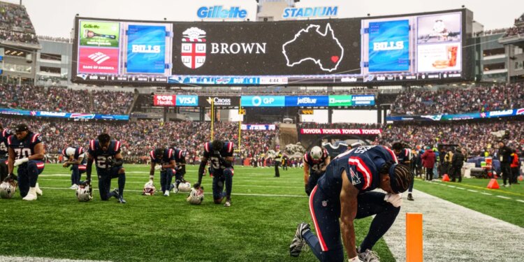 New England Patriots wide receiver Stefon Diggs (8) and teammates on the field during a tribute for the victim of the shooting at Brown University in Providence RI before the start of the game against the Buffalo Bills at Gillette Stadium.