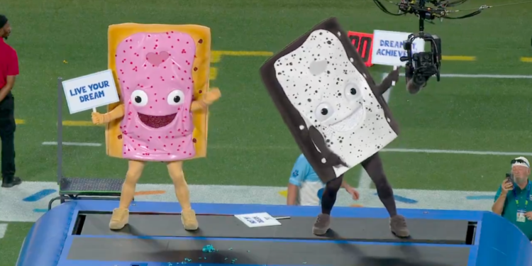Two people in Pop-Tart mascot costumes on a platform at a football game.