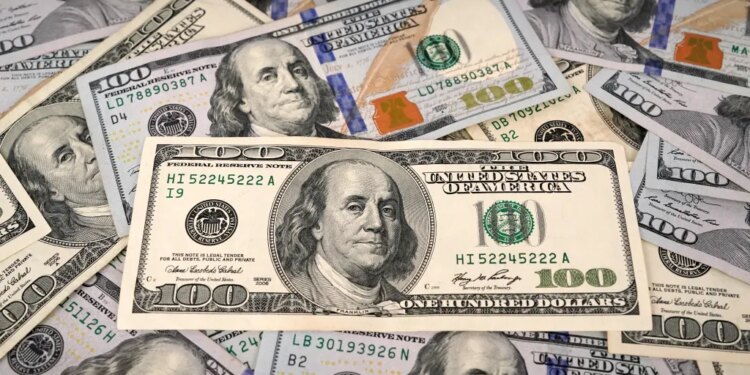 A collection of old and new style one hundred dollar bills with Benjamin Franklin's portrait visible.