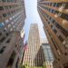 75 Rockefeller Plaza viewed from below, showing the building's exterior and several adjacent skyscrapers.