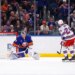 New York Islanders goalie David Rittich deflects the puck from New York Rangers player Carson Soucy.