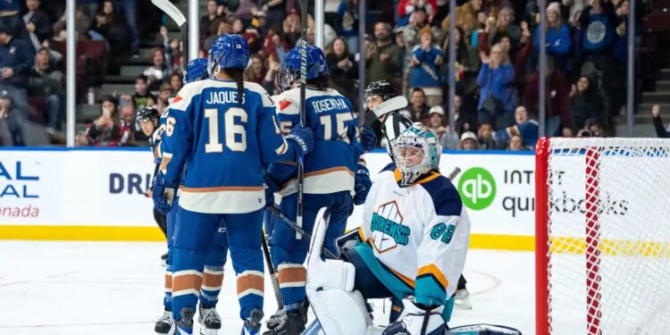 The Vancouver Goldeneyes' Sophie Jaques and Gabby Rosenthal celebrate after a goal by Abby Boreen (obscured) past Sirens goaltender Kayle Osborne during the third period of Saturday's game in Vancouver, British Columbia.