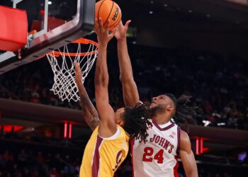 Lamin Sabally of Iona Gaels shooting the basketball as Zuby Ejiofor of St. John's Red Storm defends.