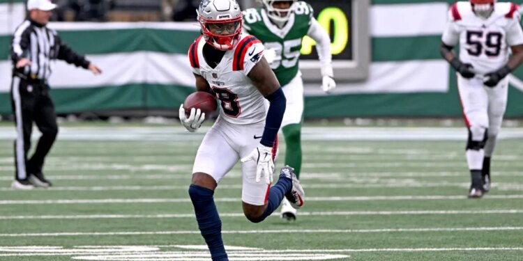 Patriots wide receiver Stefon Diggs (8) runs with the ball on the field.