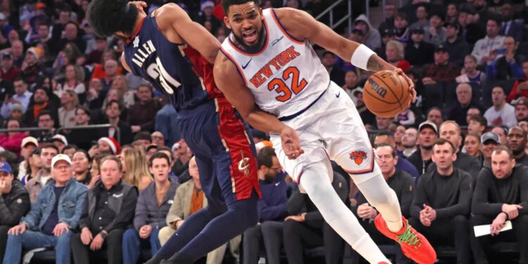New York Knicks center Karl-Anthony Towns #32 is called for an offensive foul as he drives into Cleveland Cavaliers center Jarrett Allen #31 during the first quarter.