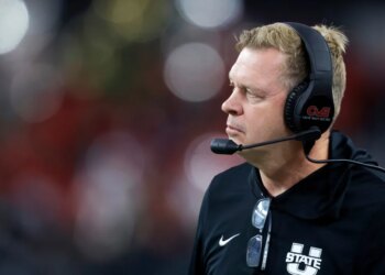 Utah State head football coach Bronco Mendenhall watching from the sideline.