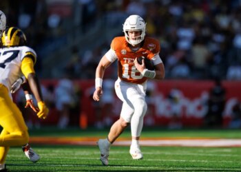 Texas Longhorns quarterback Arch Manning (16) runs with the ball against the Michigan Wolverines.