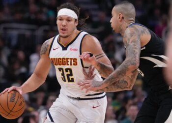 Aaron Gordon of the Denver Nuggets attempting to dribble past Kyle Kuzma of the Milwaukee Bucks during an NBA game.