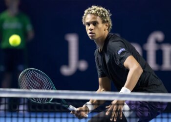 Gabriel Diallo with a tennis racket on court, returning the ball.