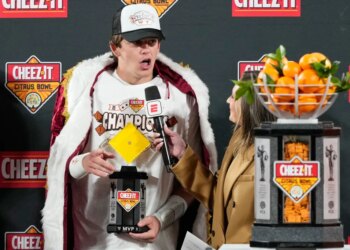 Texas quarterback Arch Manning makes remarks to fans after winning the MVP award in the Citrus Bowl NCAA college football game against Michigan, Wednesday, Dec. 31, 2025, in Orlando, Fla.