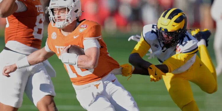 Texas quarterback Arch Manning is stopped by Michigan defensive back Jayden Sanders.