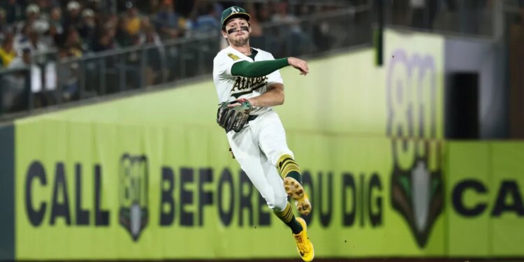 Athletics shortstop Jacob Wilson throws a baseball to first base.