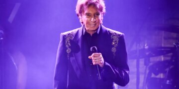 Barry Manilow performing on stage with a microphone.