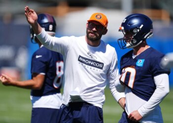 Denver Broncos quarterbacks coach Davis Webb, center, directs quarterback Bo Nix.