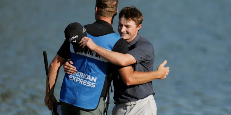 Blades Brown, right, gets a hug from his caddie Brett Swedberg as Brown finishes at the ninth green for a 12-under-par 60 during the second round of the American Express golf event at the Jack Nicklaus Tournament Course at PGA West Friday, Jan. 23, 2026, in La Quinta, Calif.