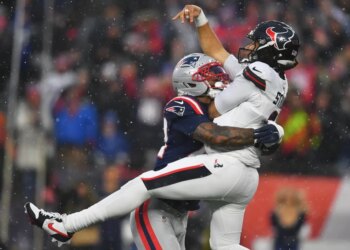New England Patriots linebacker K'lavon Chaisson hitting Houston Texans quarterback C.J. Stroud during a playoff football game.
