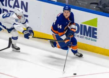 New York Islanders center Calum Ritchie (64) moves the puck down ice as Tampa Bay Lightning center Jake Guentzel (59) tries to defend during the third period at UBS Arena, Saturday, Dec. 13, 2025, in Elmont, NY.