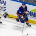 New York Islanders center Calum Ritchie (64) moves the puck down ice as Tampa Bay Lightning center Jake Guentzel (59) tries to defend during the third period at UBS Arena, Saturday, Dec. 13, 2025, in Elmont, NY.