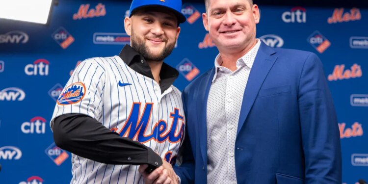 Bo Bichette in a Mets uniform shakes hands with manager Carlos Mendoza.