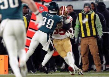Philadelphia Eagles' Marcus Epps tackling San Francisco 49ers' George Kittle during an NFL wild-card playoff football game.
