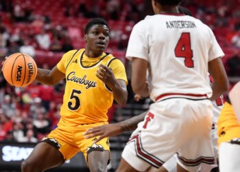 Wyoming guard Leland Walker (5) dribbles the ball during the second half in an NCAA college basketball game against Texas Tech.