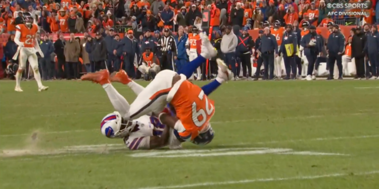 A Bills player in white and a Broncos player in orange tackle each other on a football field.