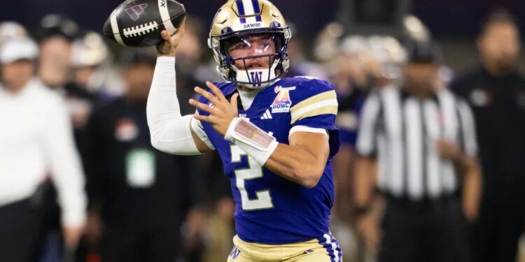 A Boise State Washington football player in a purple jersey and gold helmet throwing a football.