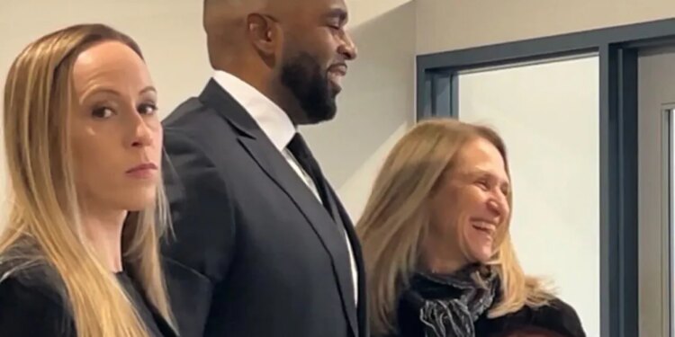 Kelli Moore, Sherrone Moore, and attorney Ellen Michaels at a court hearing.