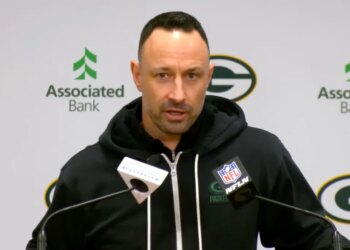 Jon-Eric Sullivan speaks into two microphones at a press conference.