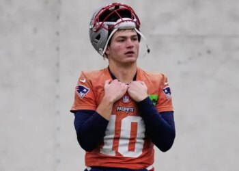New England Patriots quarterback Drake Maye in uniform with his helmet on his head.