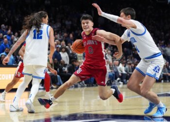 St. John's Dylan Darling drives the basketball past Xavier's Filip Borovicanin.