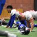 New York Giants defensive back Sam Beal #23 and other players stretch on the ground during practice.